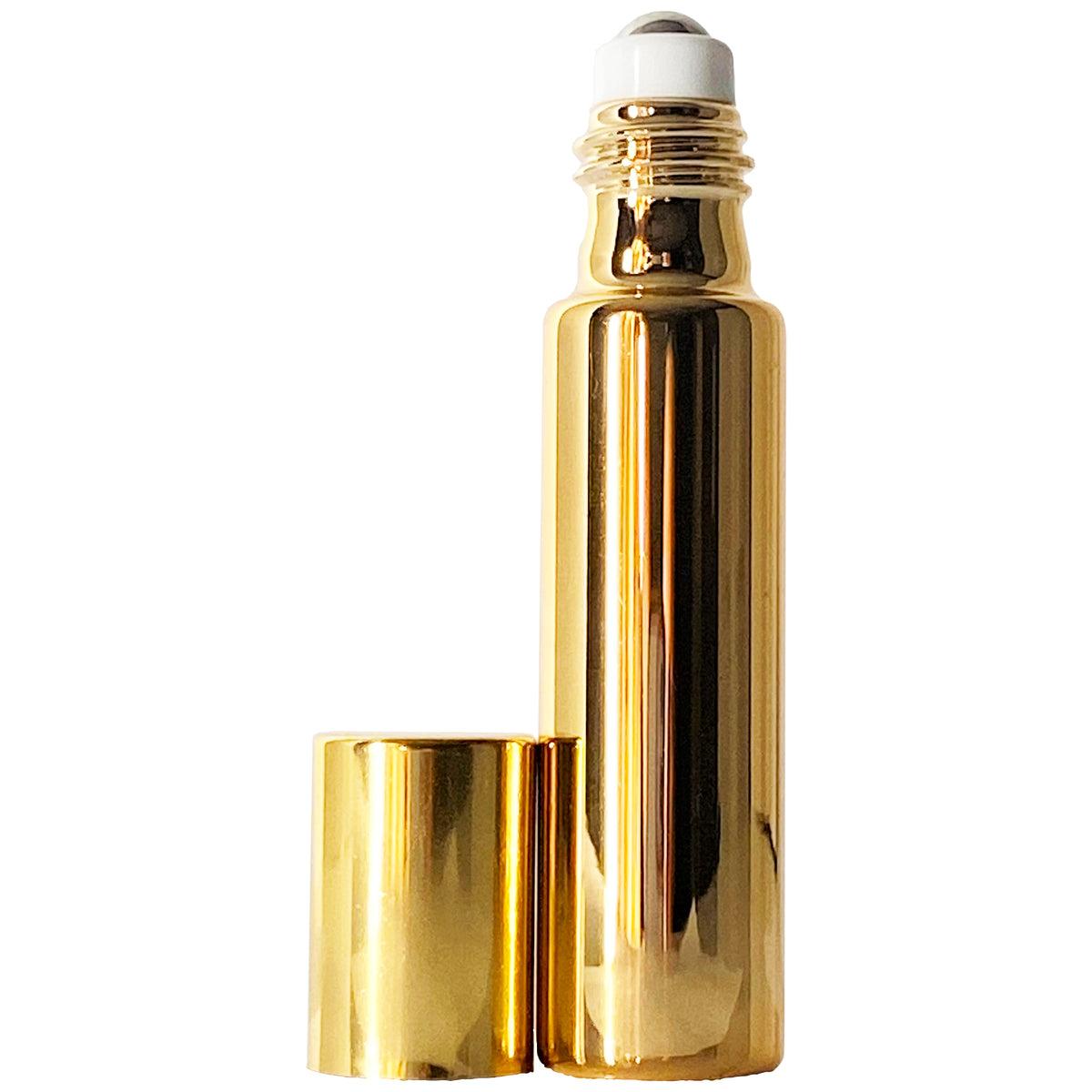 A shiny gold metal roller bottle with a white roller ball and a matching gold cap placed beside it on a plain white background.